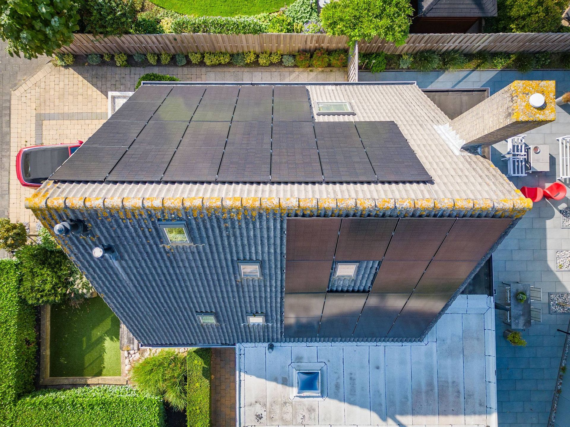 Een luchtfoto van een huis met zonnepanelen op het dak.