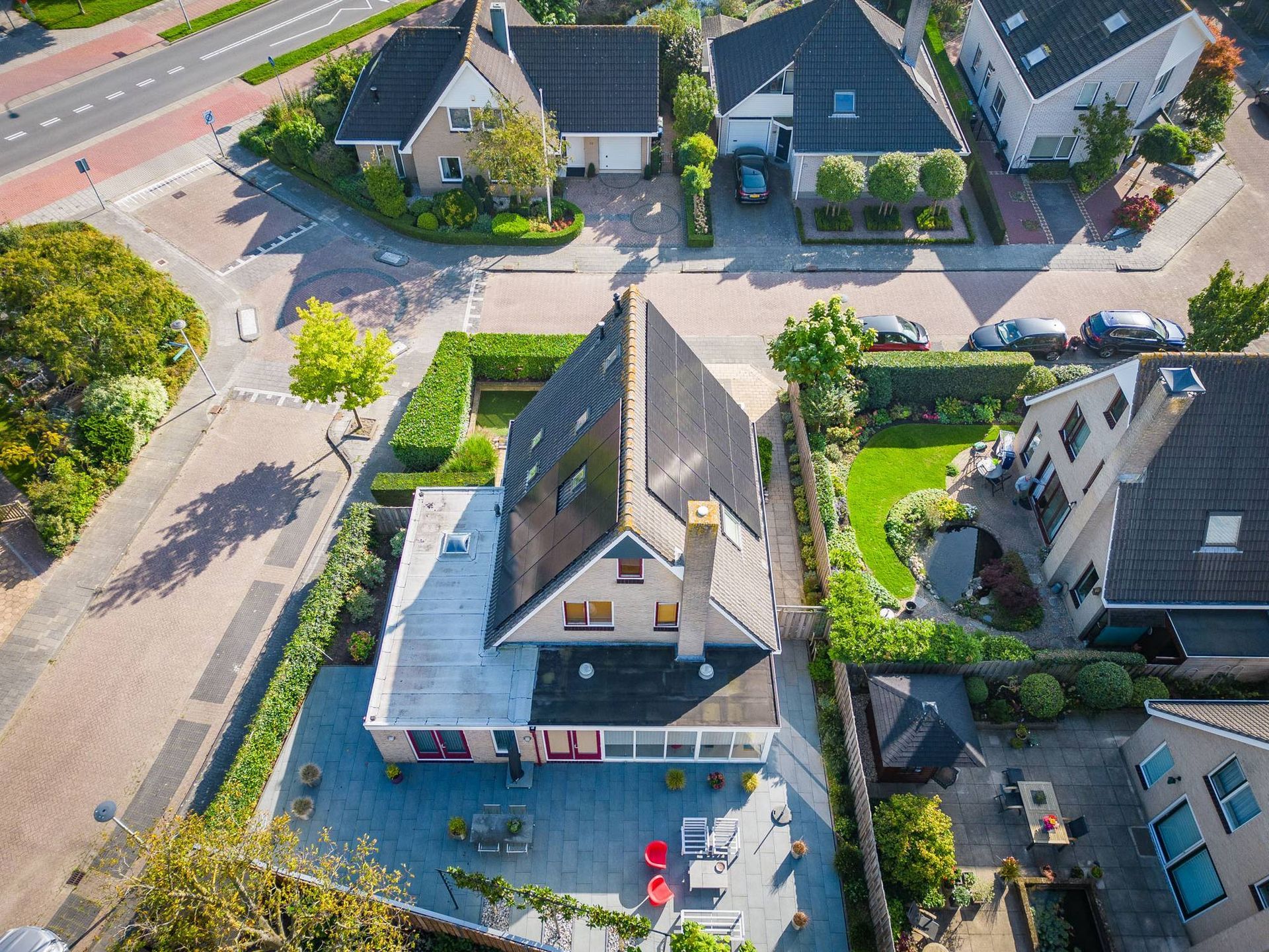 Een luchtfoto van een woonwijk met een groot huis in het midden.
