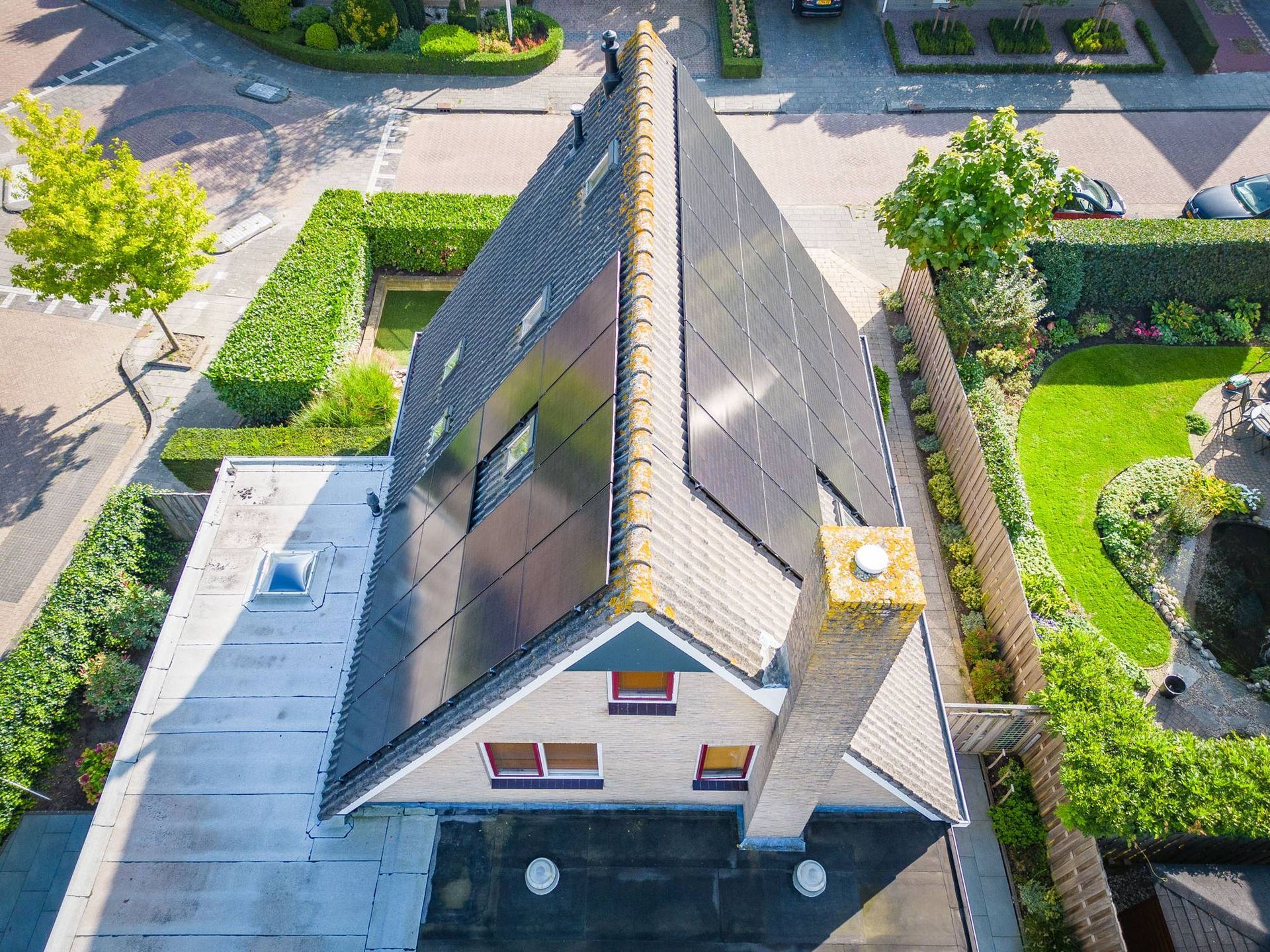 Een luchtfoto van een huis met zonnepanelen op het dak.