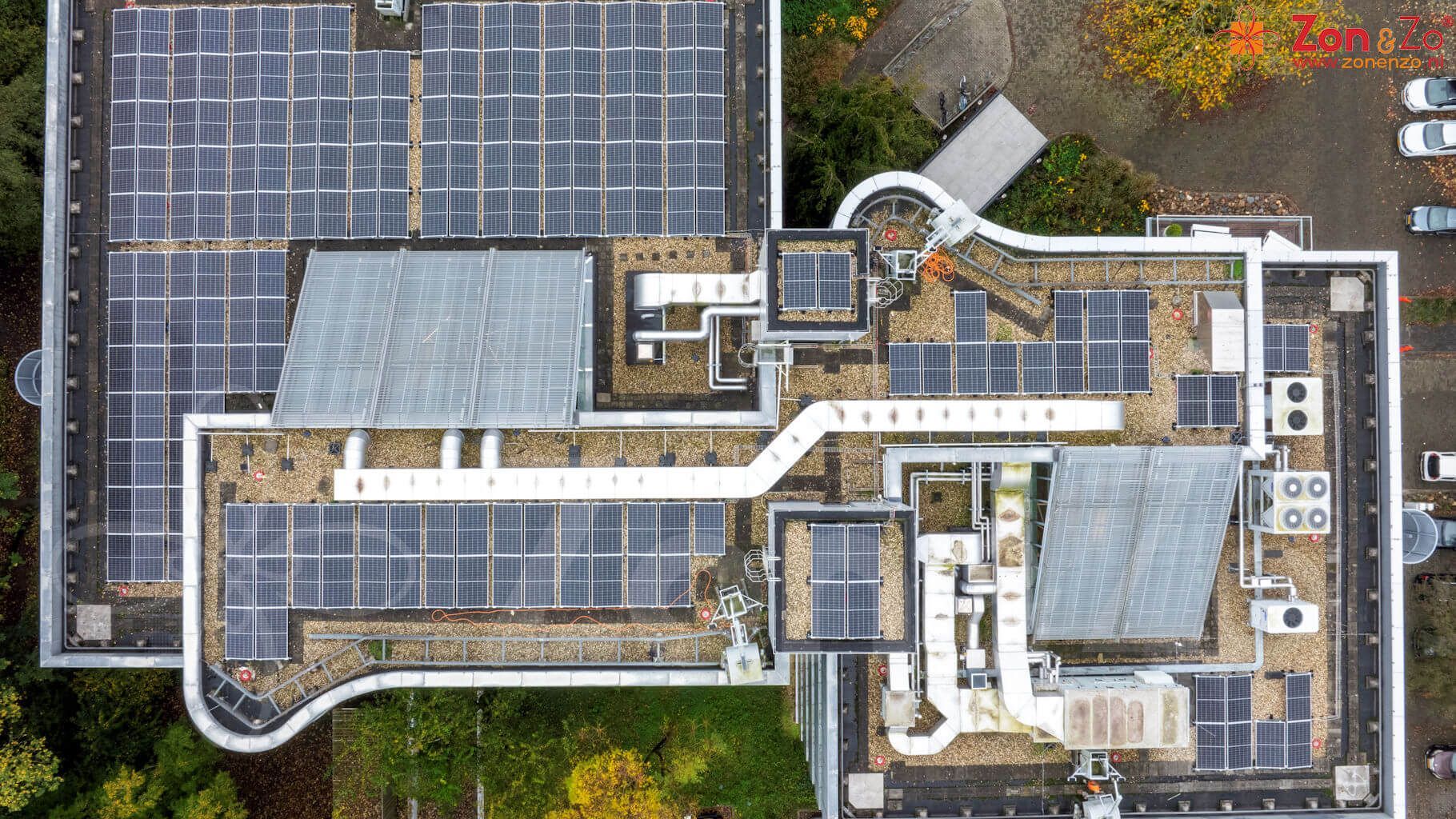 Een luchtfoto van een groot gebouw met zonnepanelen op het dak.