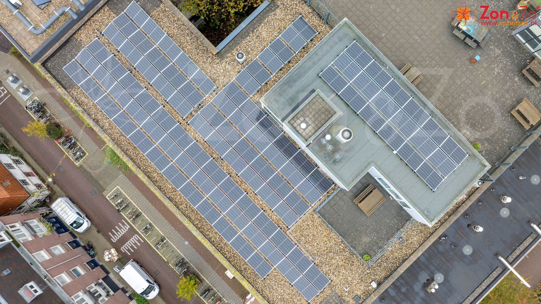Een luchtfoto van een gebouw met zonnepanelen op het dak.