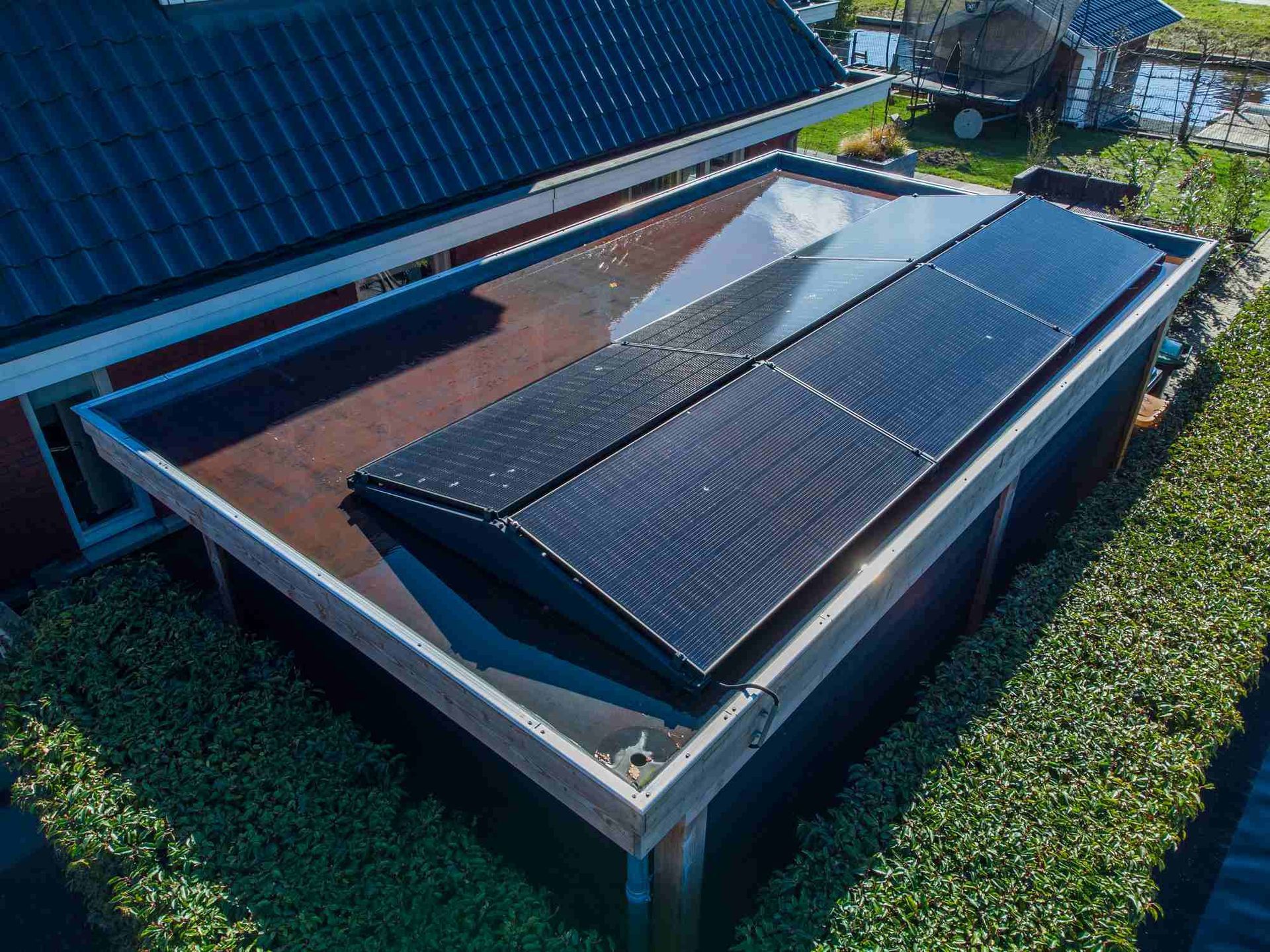 Een luchtfoto van een huis met zonnepanelen op het dak.