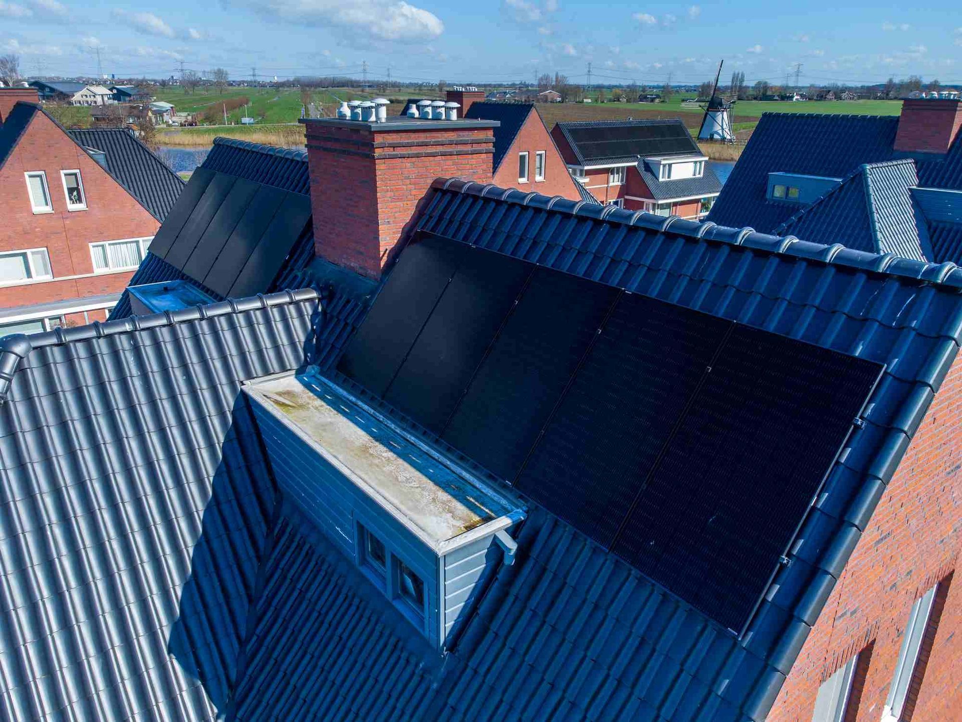 Een luchtfoto van een dak met zonnepanelen erop.