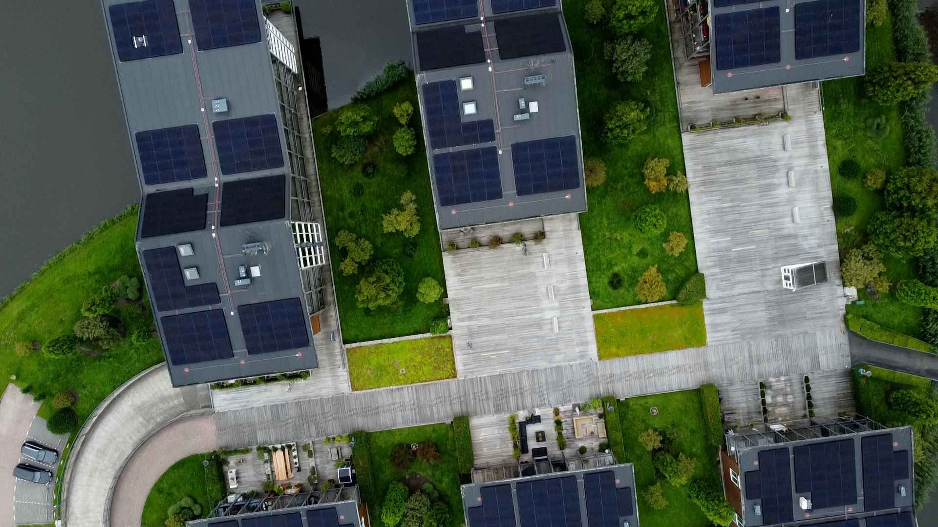 Een luchtfoto van een woonwijk met veel zonnepanelen op de gebouwen.