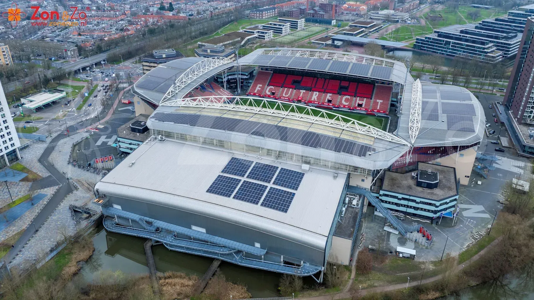 Een luchtfoto van een voetbalstadion met zonnepanelen op het dak.
