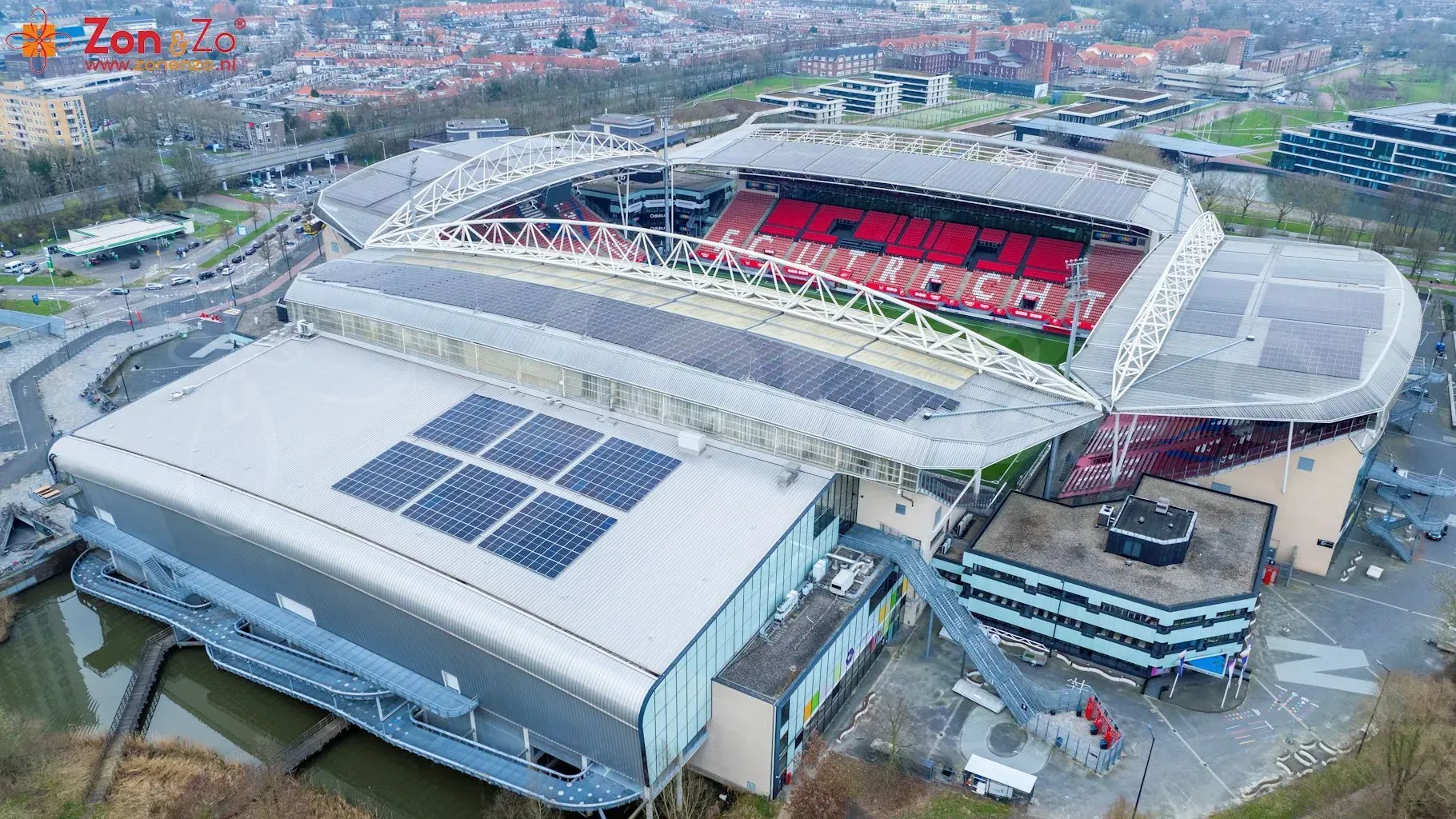 Een luchtfoto van een voetbalstadion met zonnepanelen op het dak.