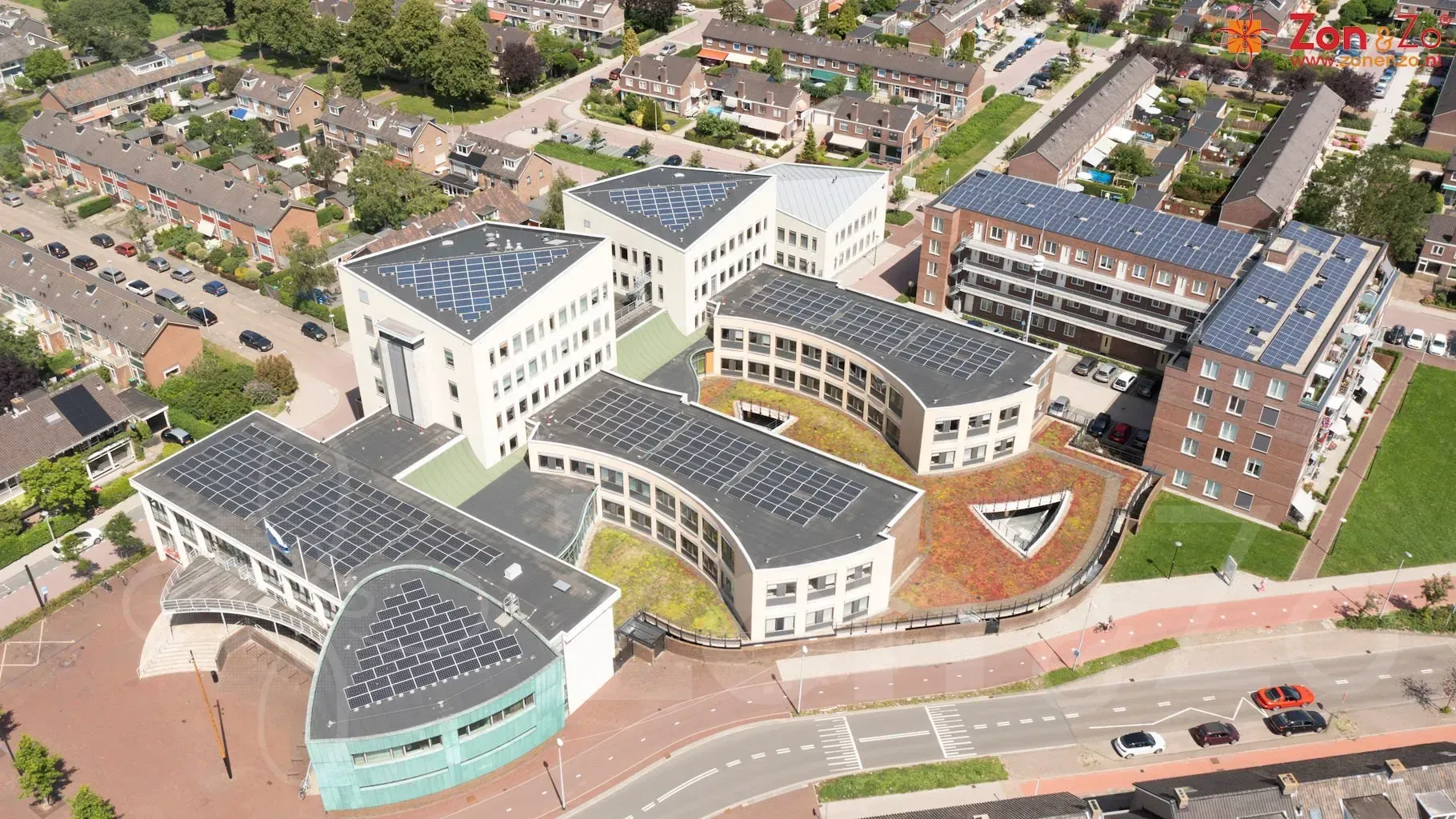 Een luchtfoto van een groot gebouw met zonnepanelen op het dak.
