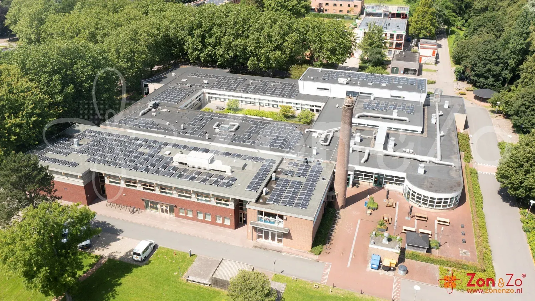 Een luchtfoto van een groot gebouw met zonnepanelen op het dak