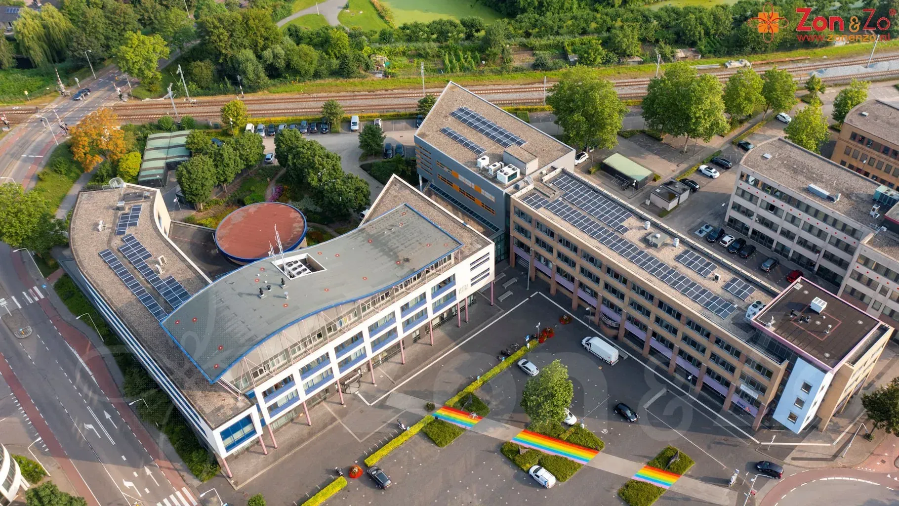 Een luchtfoto van een groot gebouw met zonnepanelen op het dak.
