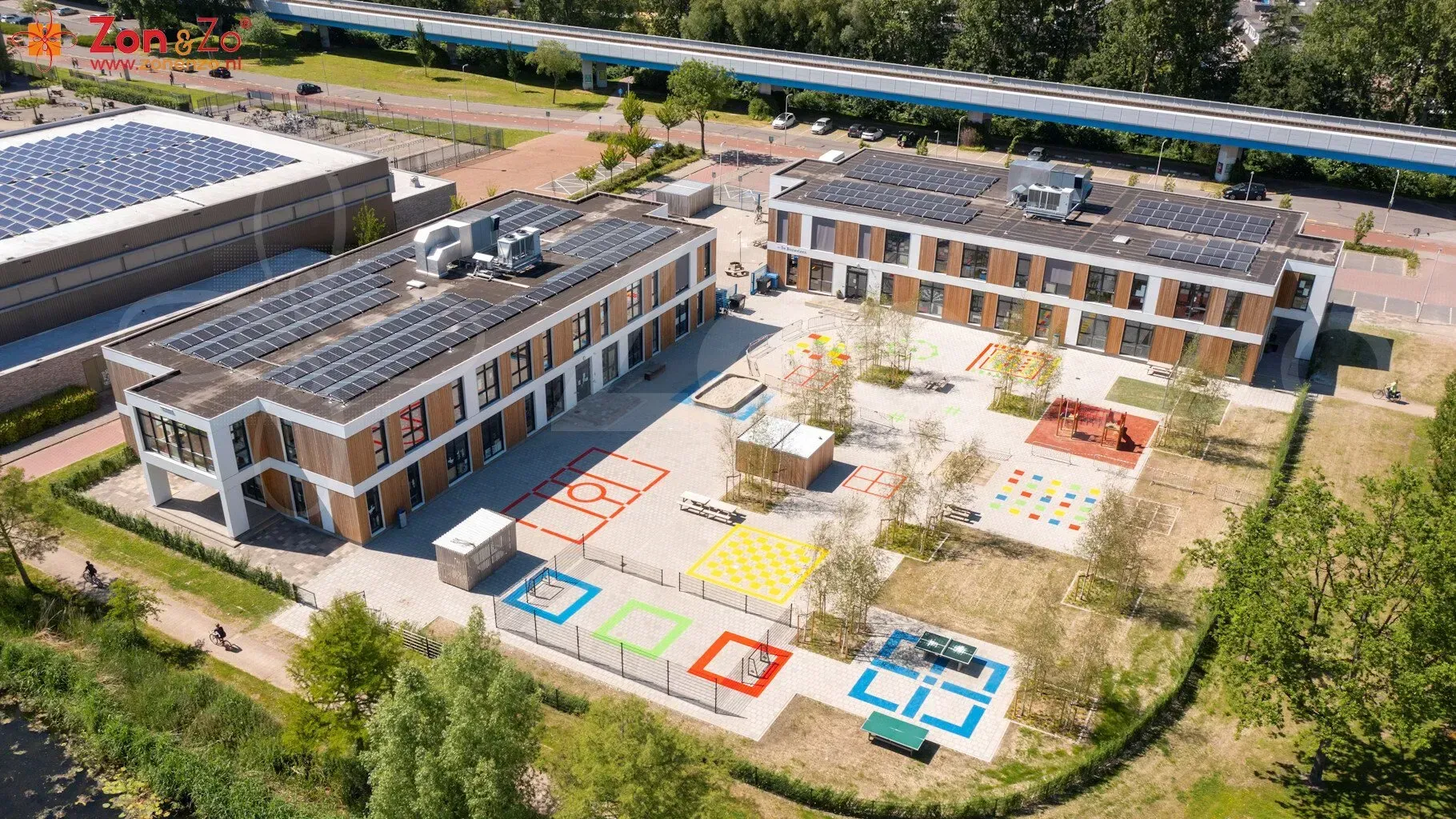Een luchtfoto van een groot gebouw met zonnepanelen op het dak.