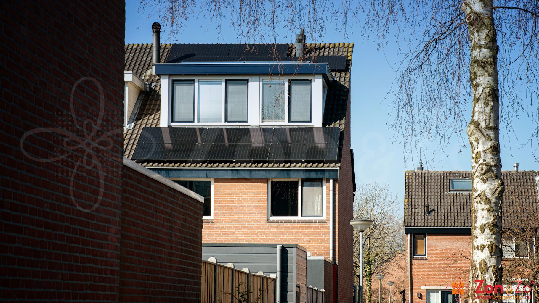 Een bakstenen huis met zonnepanelen op het dak