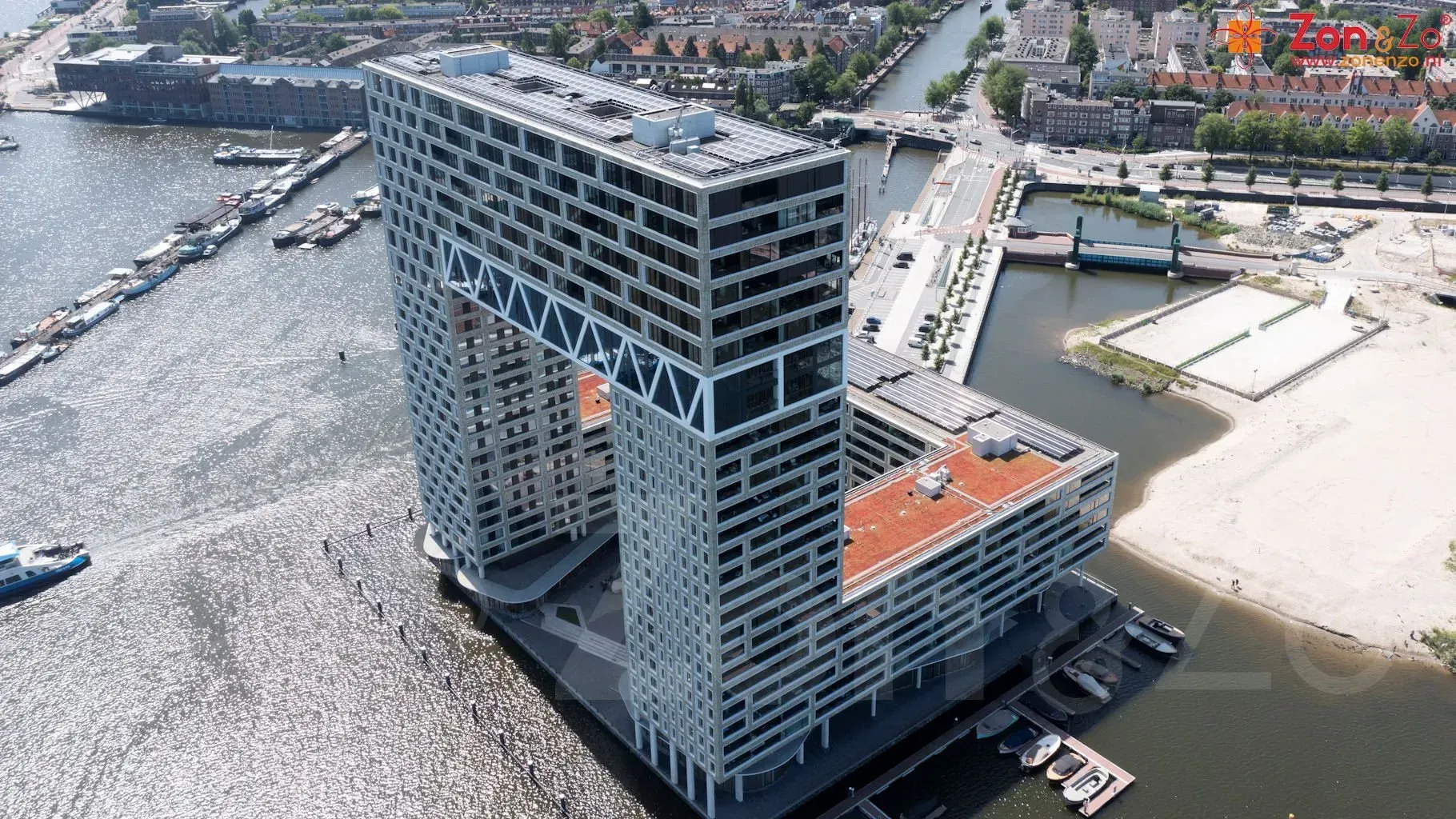 Een luchtfoto van een groot gebouw naast een waterlichaam