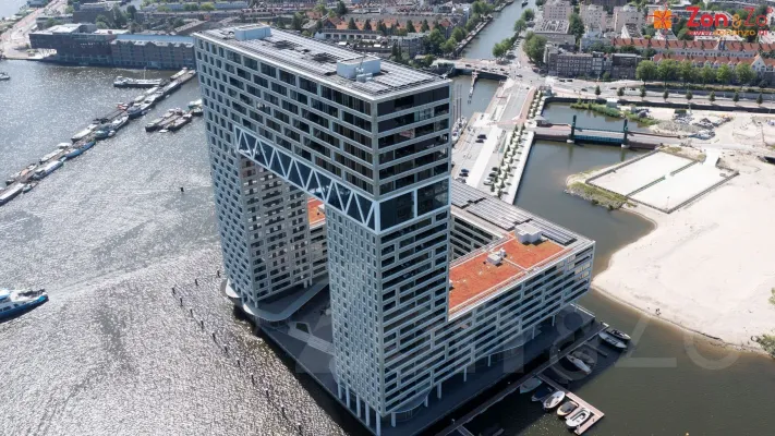 Een luchtfoto van een groot gebouw naast een waterlichaam