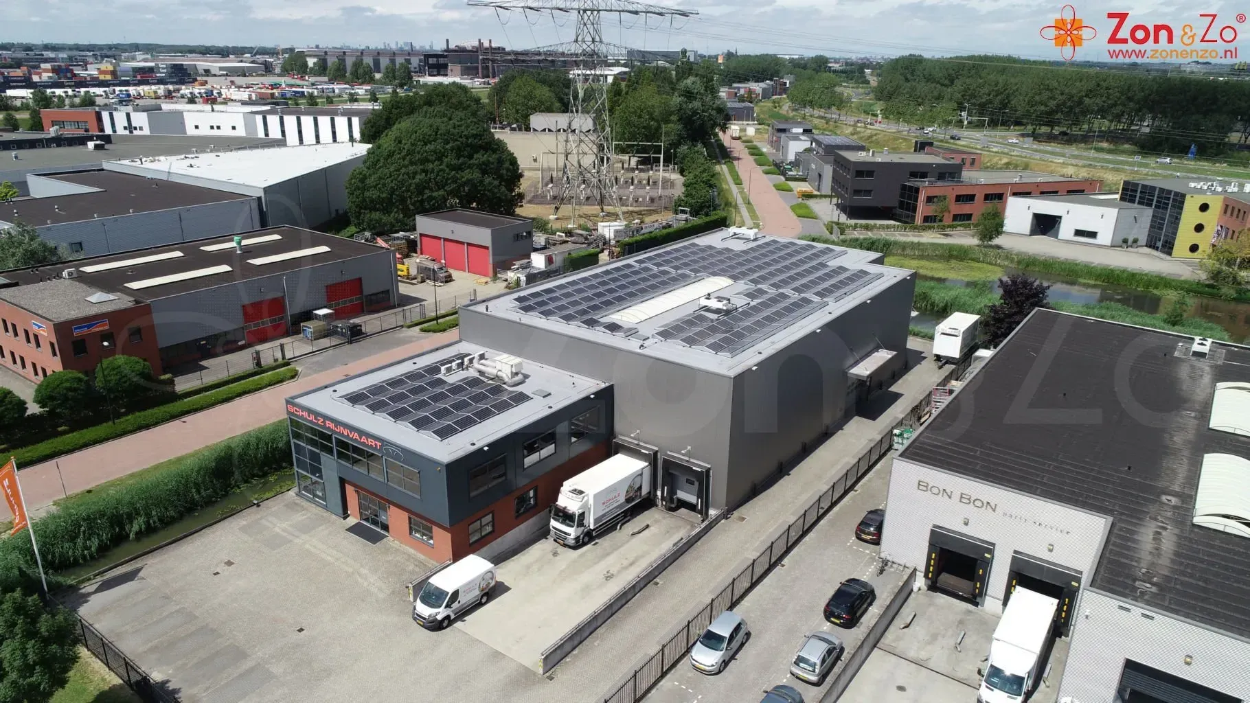 Een luchtfoto van een magazijn met zonnepanelen op het dak