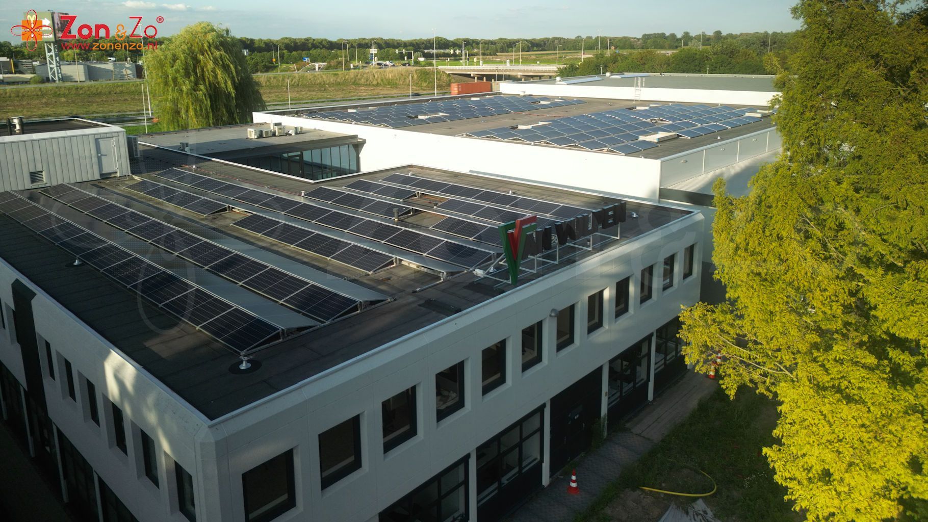 Een luchtfoto van een gebouw met zonnepanelen op het dak