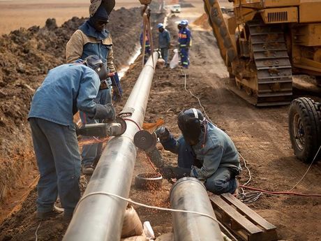 A group of construction workers are working on a pipe.