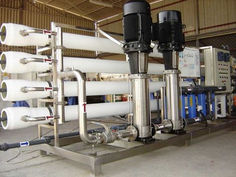 A row of white pipes and pumps in a warehouse