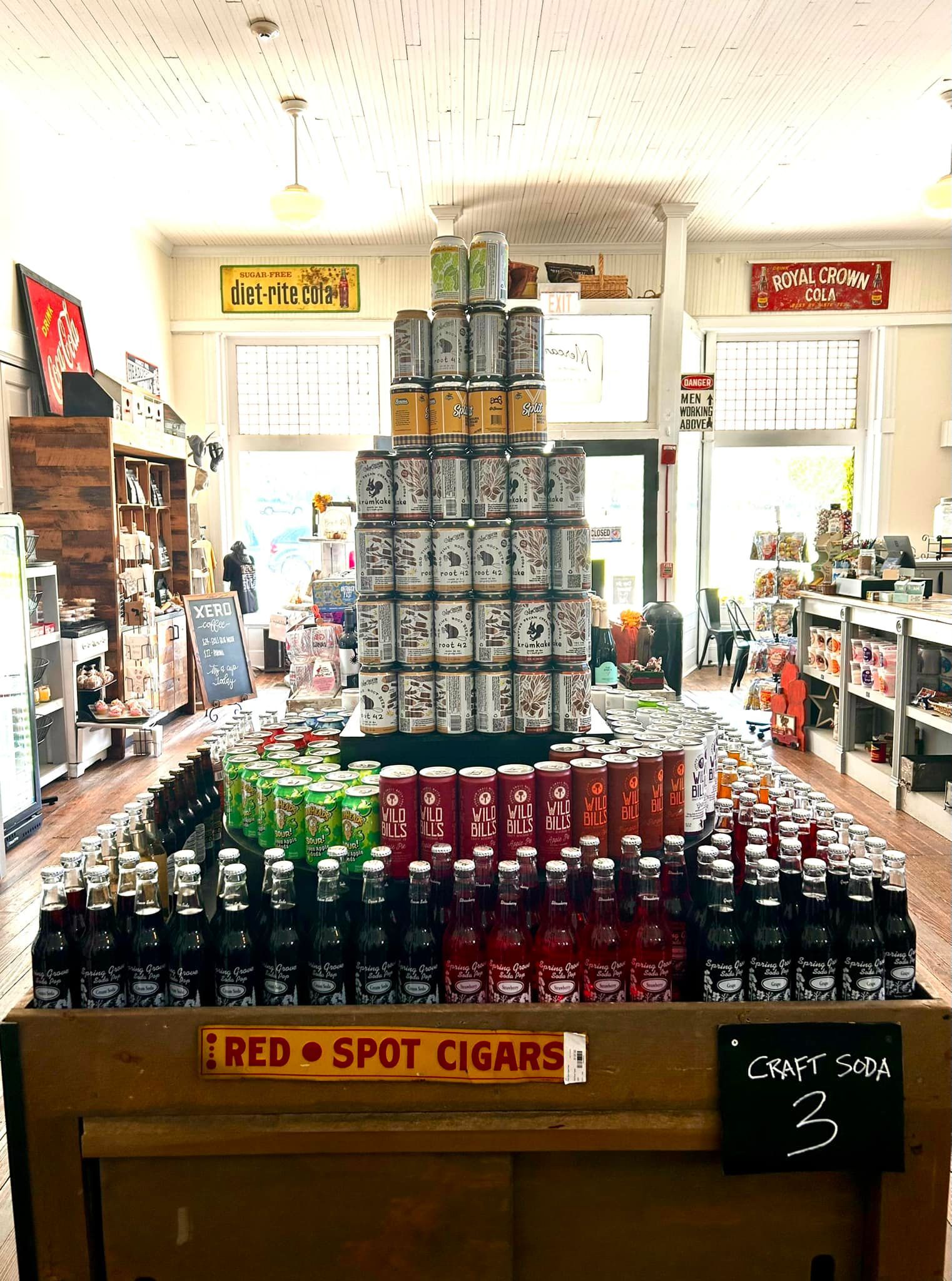 A display of cans and bottles in a store with a sign that says `` red spot cigars ''.