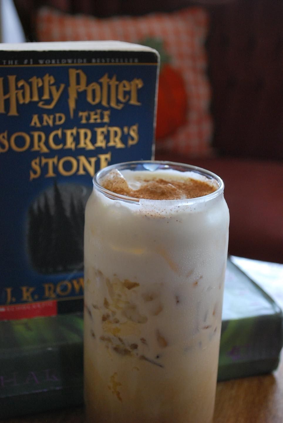 A woman is holding a milkshake in front of her face.