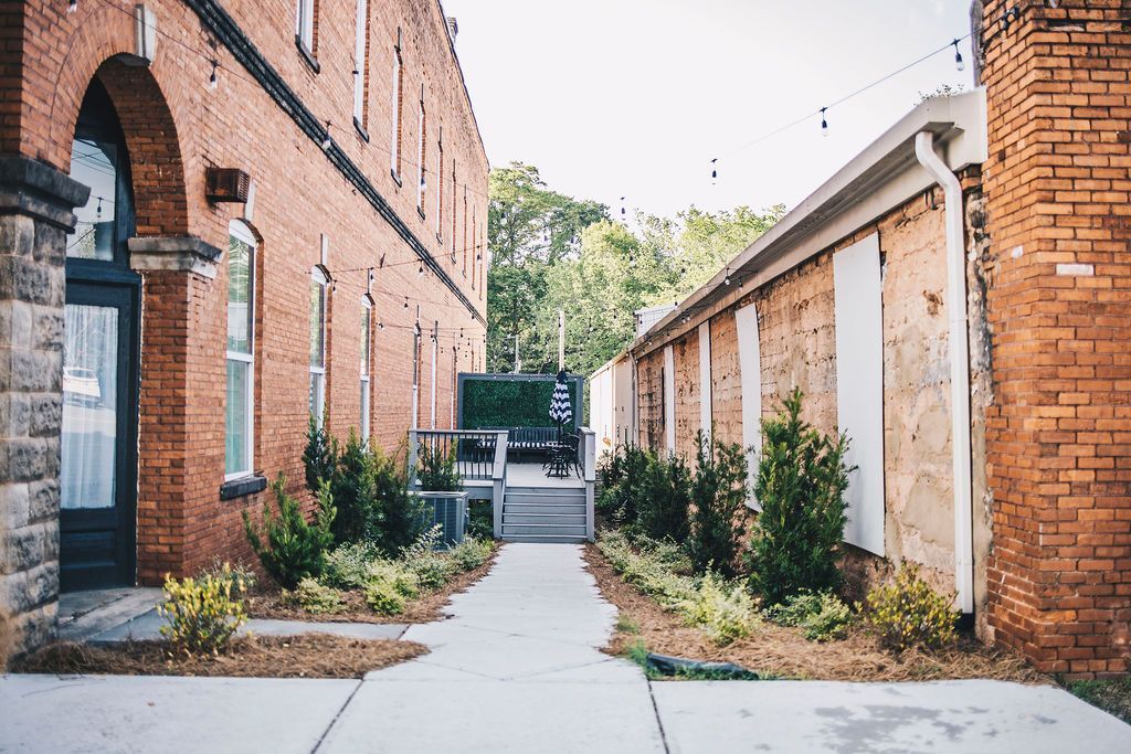 A brick building with a concrete walkway between it and another building.