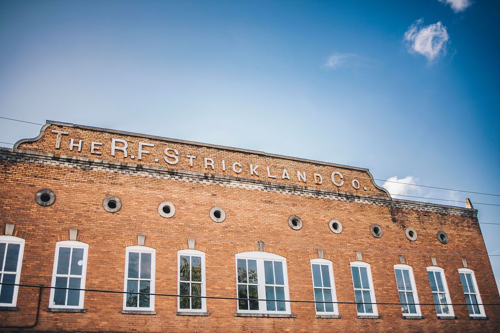 A large brick building with a lot of windows and a blue sky in the background.