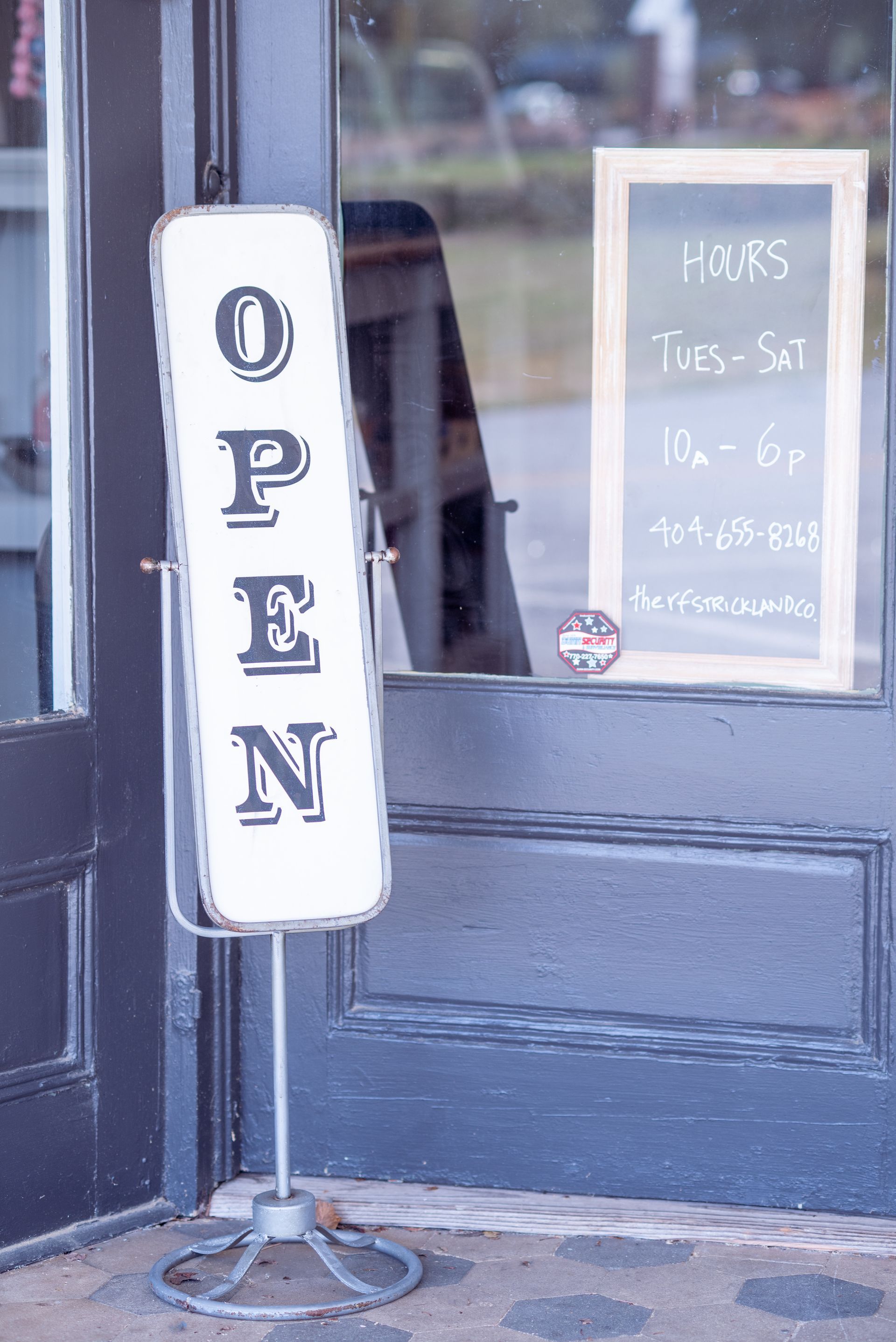 A sign that says `` open '' is standing in front of a door.