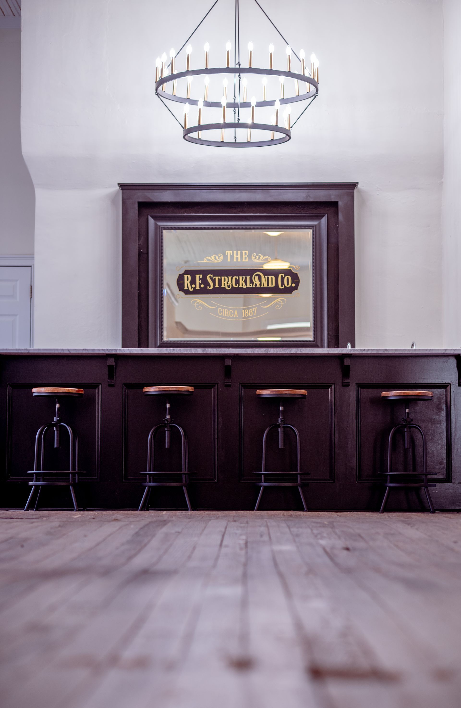 A bar with stools and a mirror that says old brewing co.