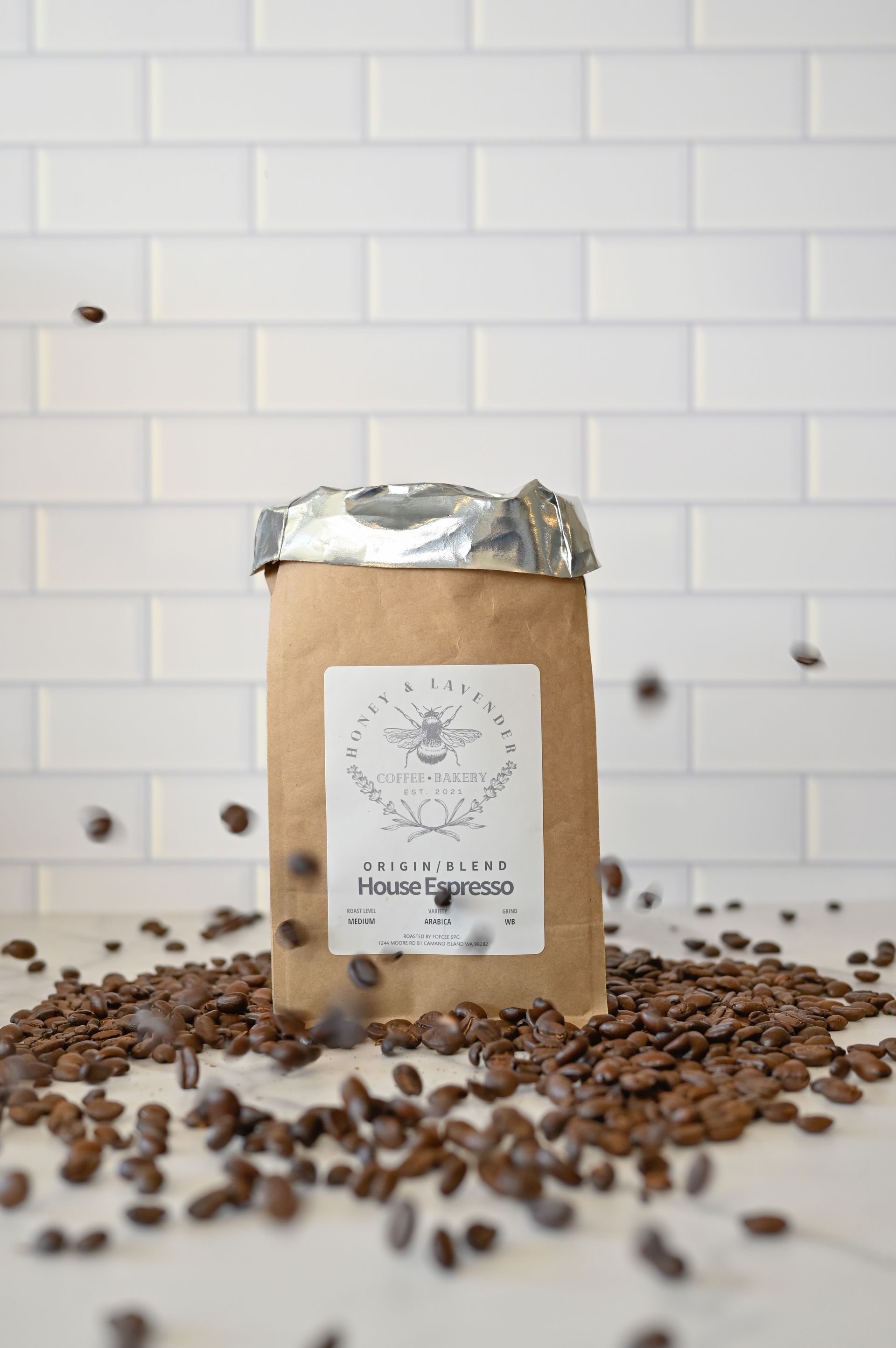A bag of coffee beans is sitting on top of a pile of coffee beans.