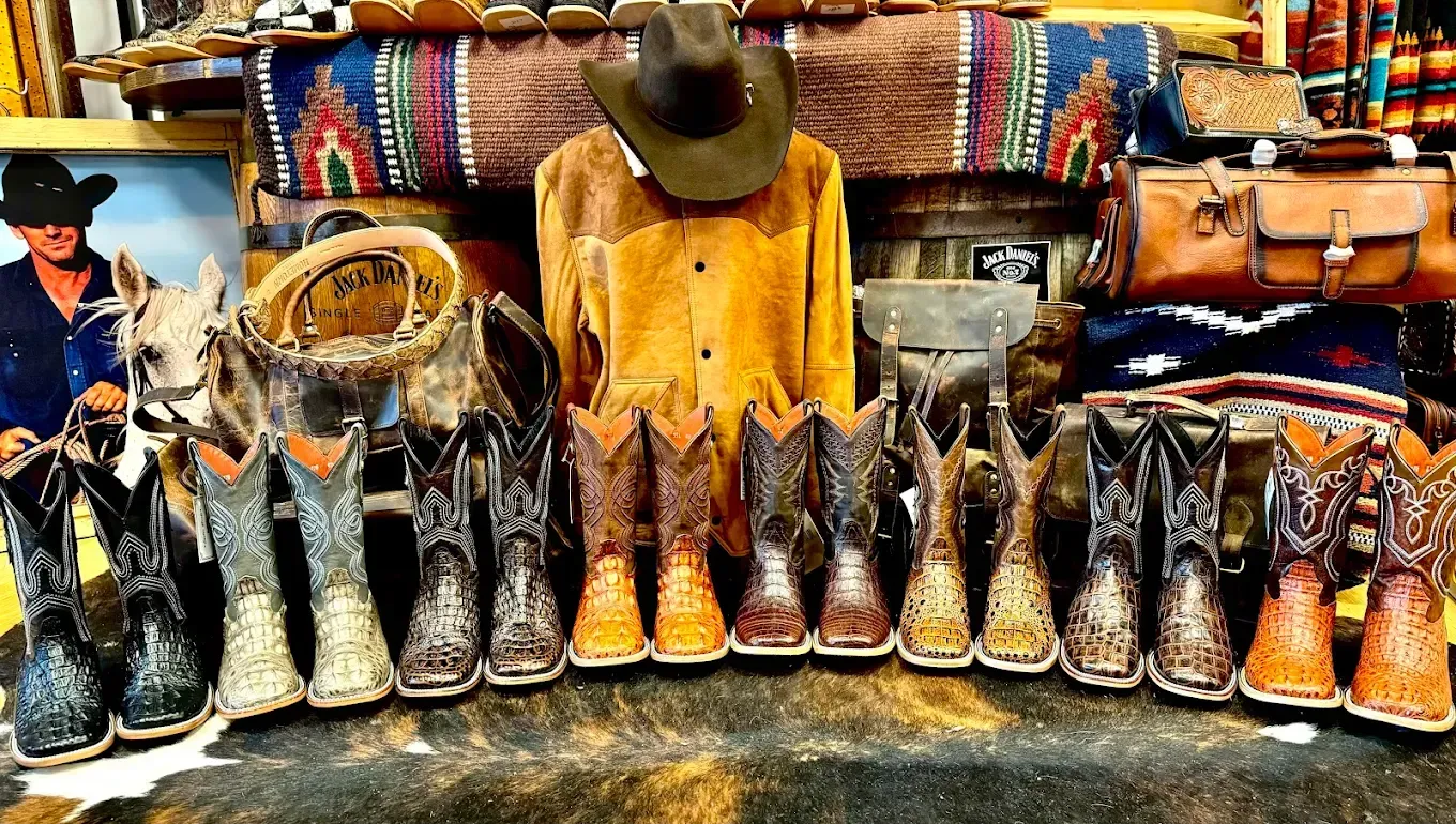 Three shot glasses of espresso are being poured from a coffee machine.