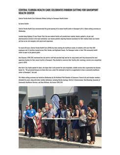 A group of people are cutting a ribbon in front of a building.