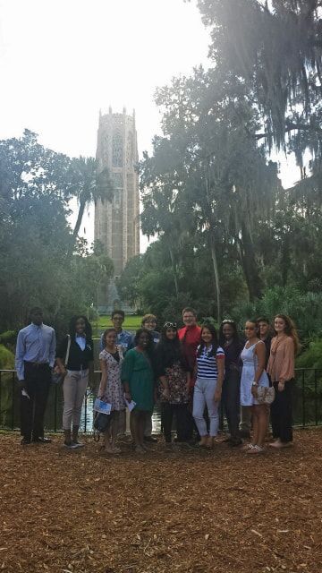 A group of people are posing for a picture in a park.