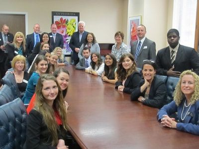 A group of people are sitting around a long table