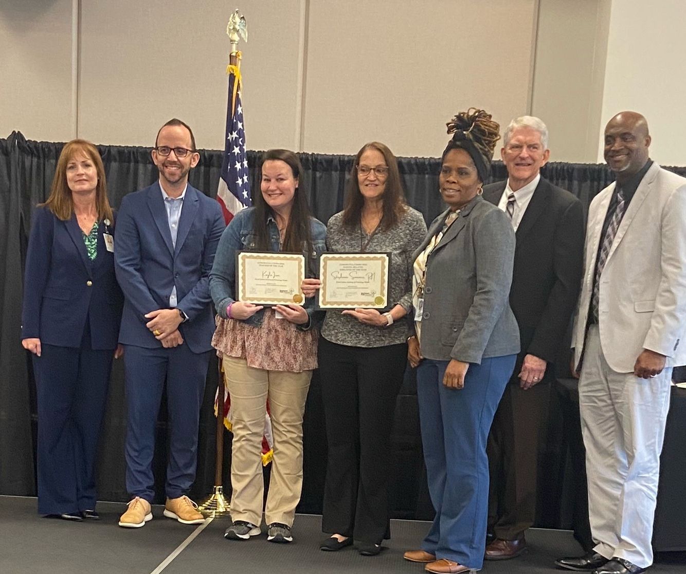 A group of people standing next to each other holding certificates.