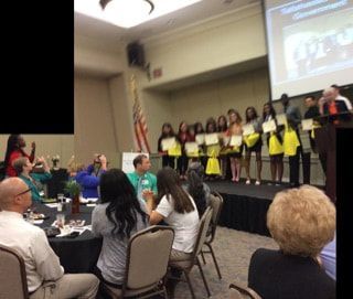 A group of people are sitting in a room watching a presentation