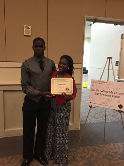 A man and a woman are standing next to each other holding a certificate.