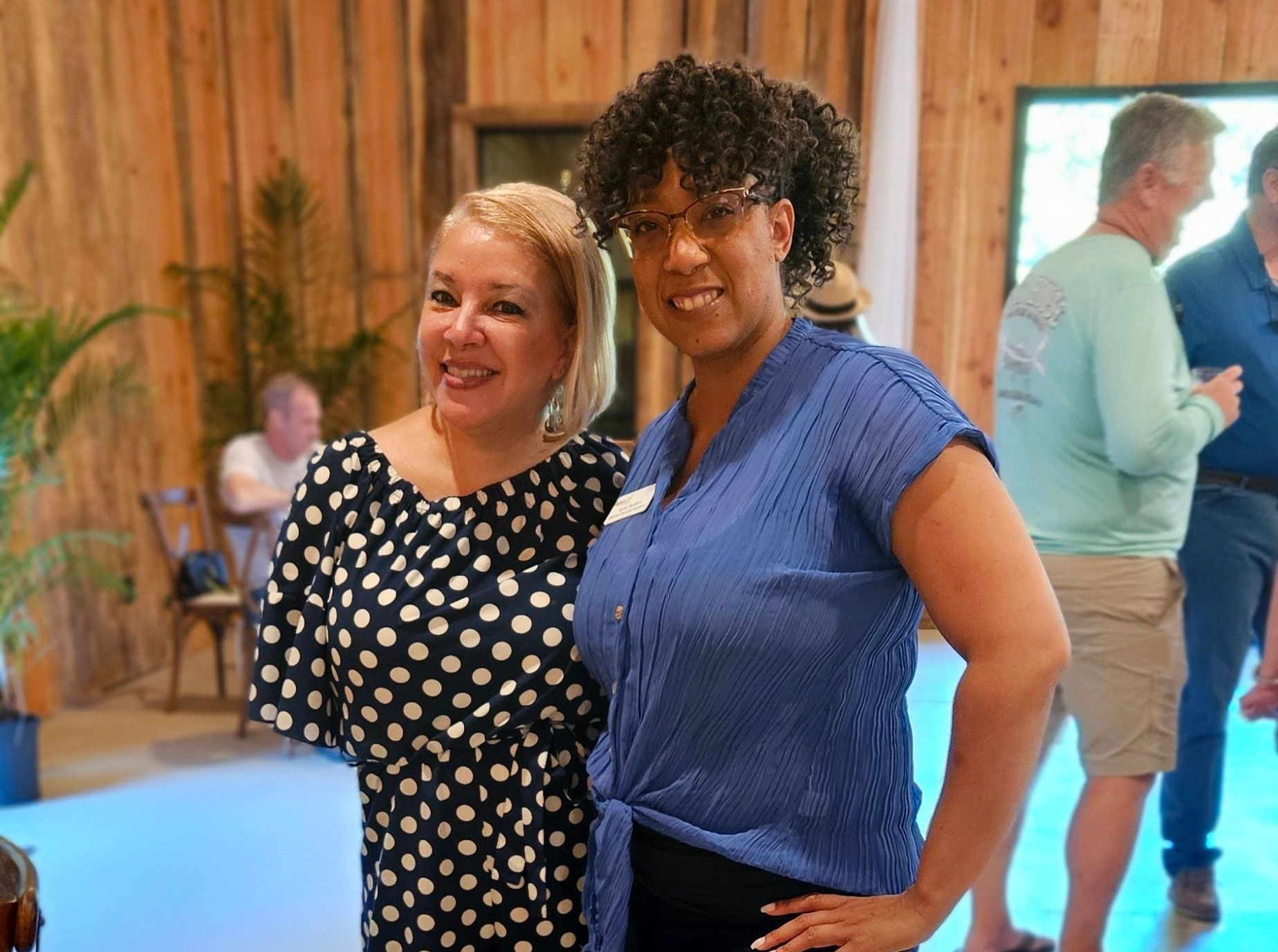 Two women are posing for a picture together in a room.