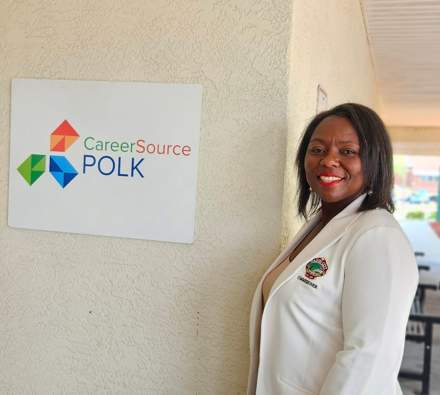 A woman stands in front of a sign that says careersource polk