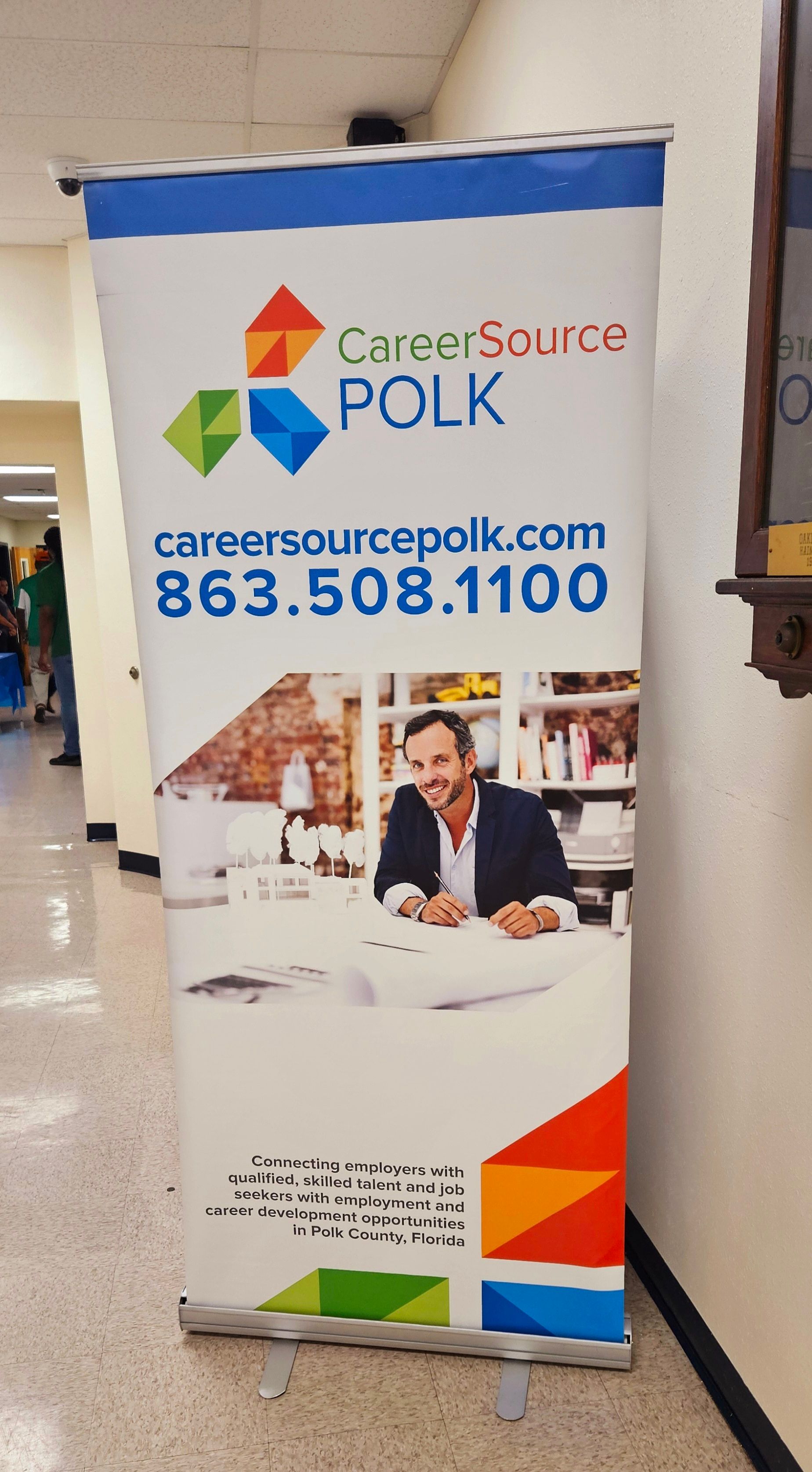 A banner for career source polk is hanging on a wall