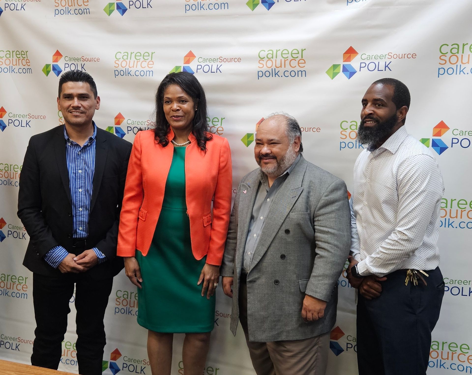 A group of people standing in front of a wall that says career source