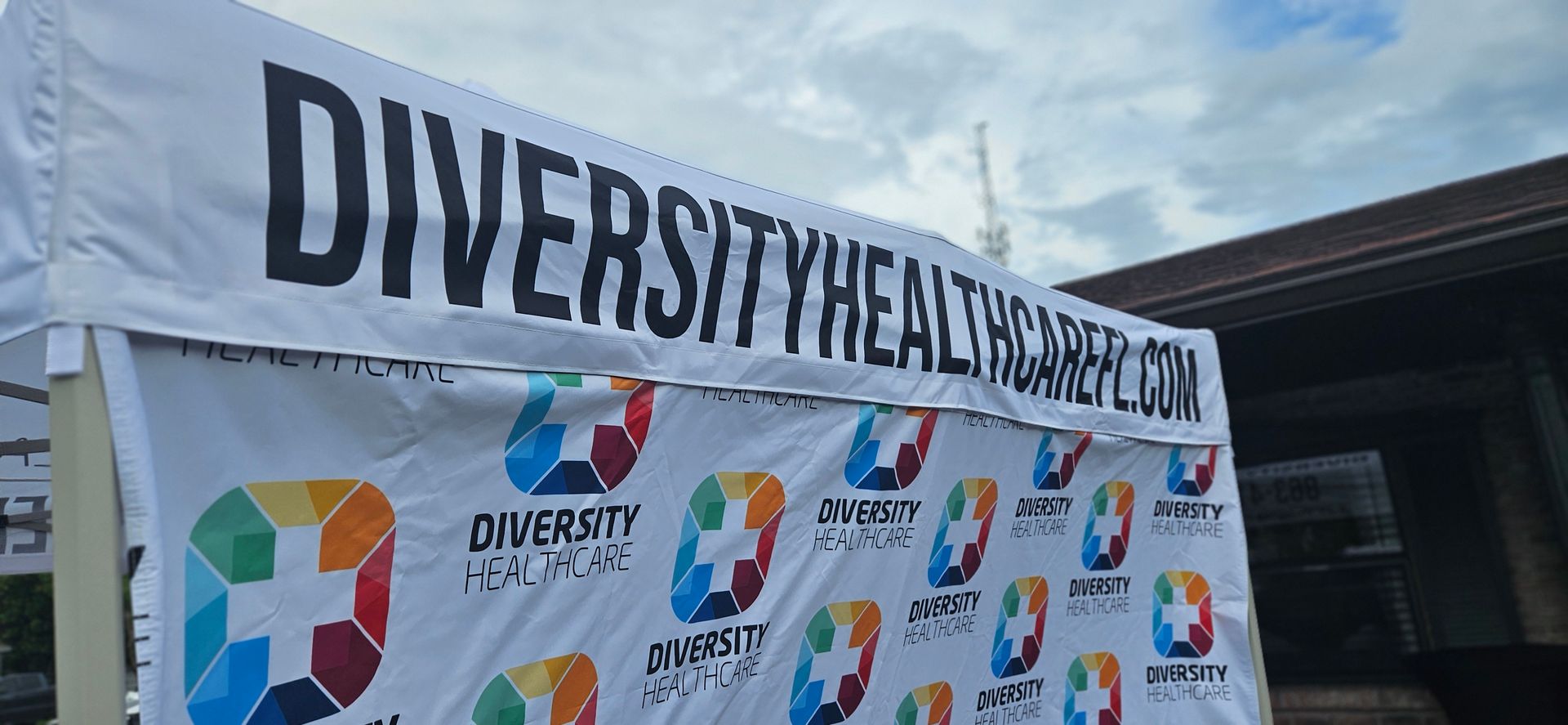 A white tent with a banner that says diversity on it