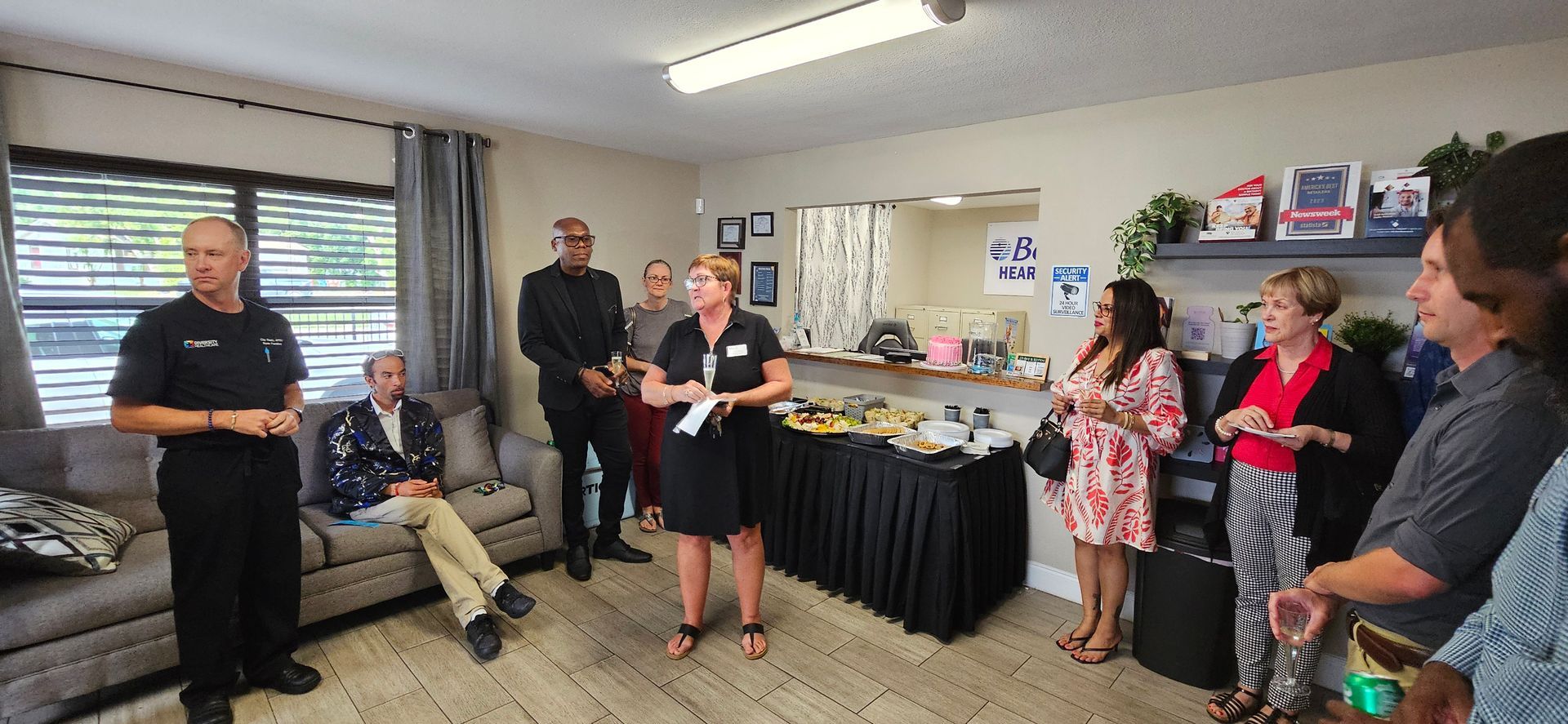 A group of people are standing around a table in a living room.