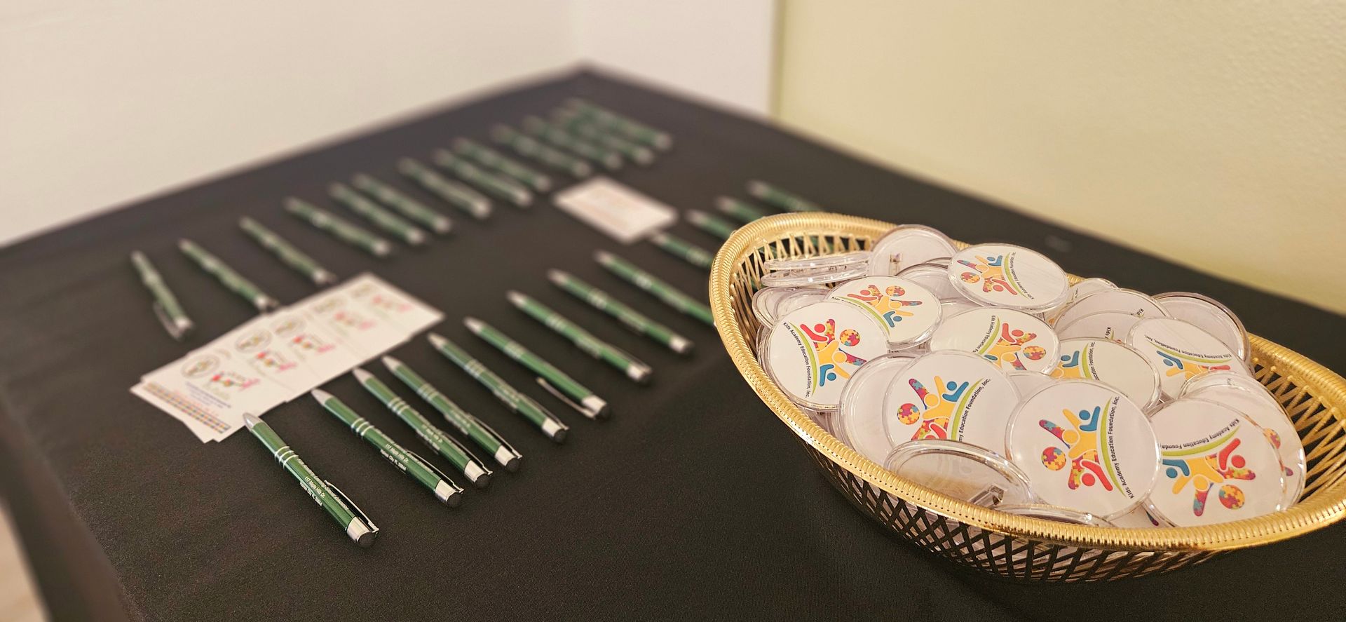 A table with a basket of buttons and pens on it.