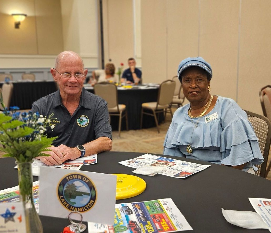 A man and a woman are sitting at a table in a room