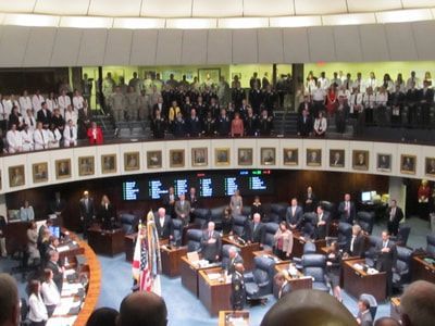A large group of people are gathered in a large room with a sign that says ' eee ' on it