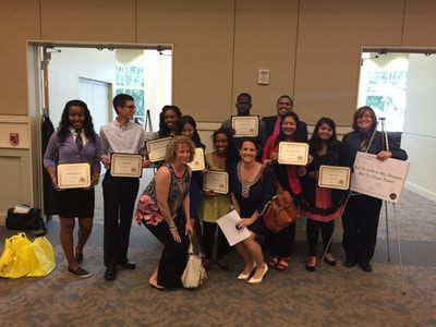 A group of people are posing for a picture while holding certificates.