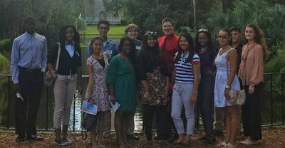 A group of people are posing for a picture in front of a lake.
