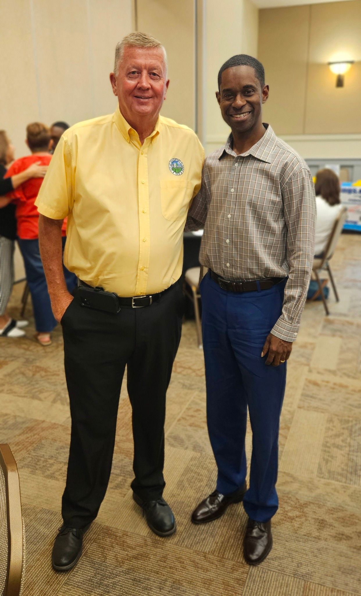 Two men are posing for a picture together in a room.