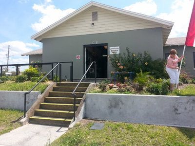 A woman is holding a red flag in front of a building