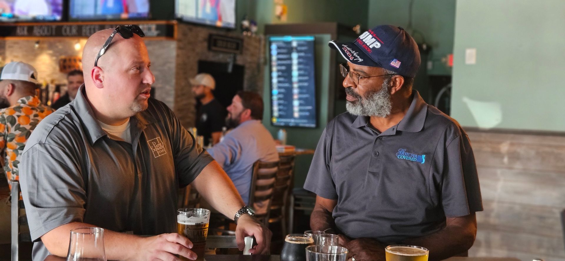 Two men are sitting at a table in a restaurant drinking beer.