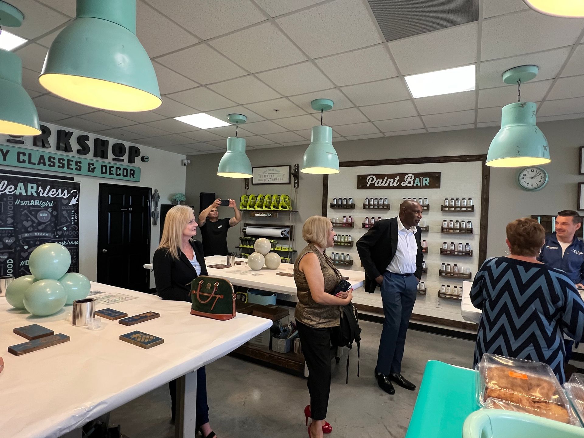 A group of people are standing around a table in a room.